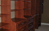 After picture of new closset sytem, two hutches and combination towers with shelves and hanging. Warm Cognac color with Raised Panel Finish.